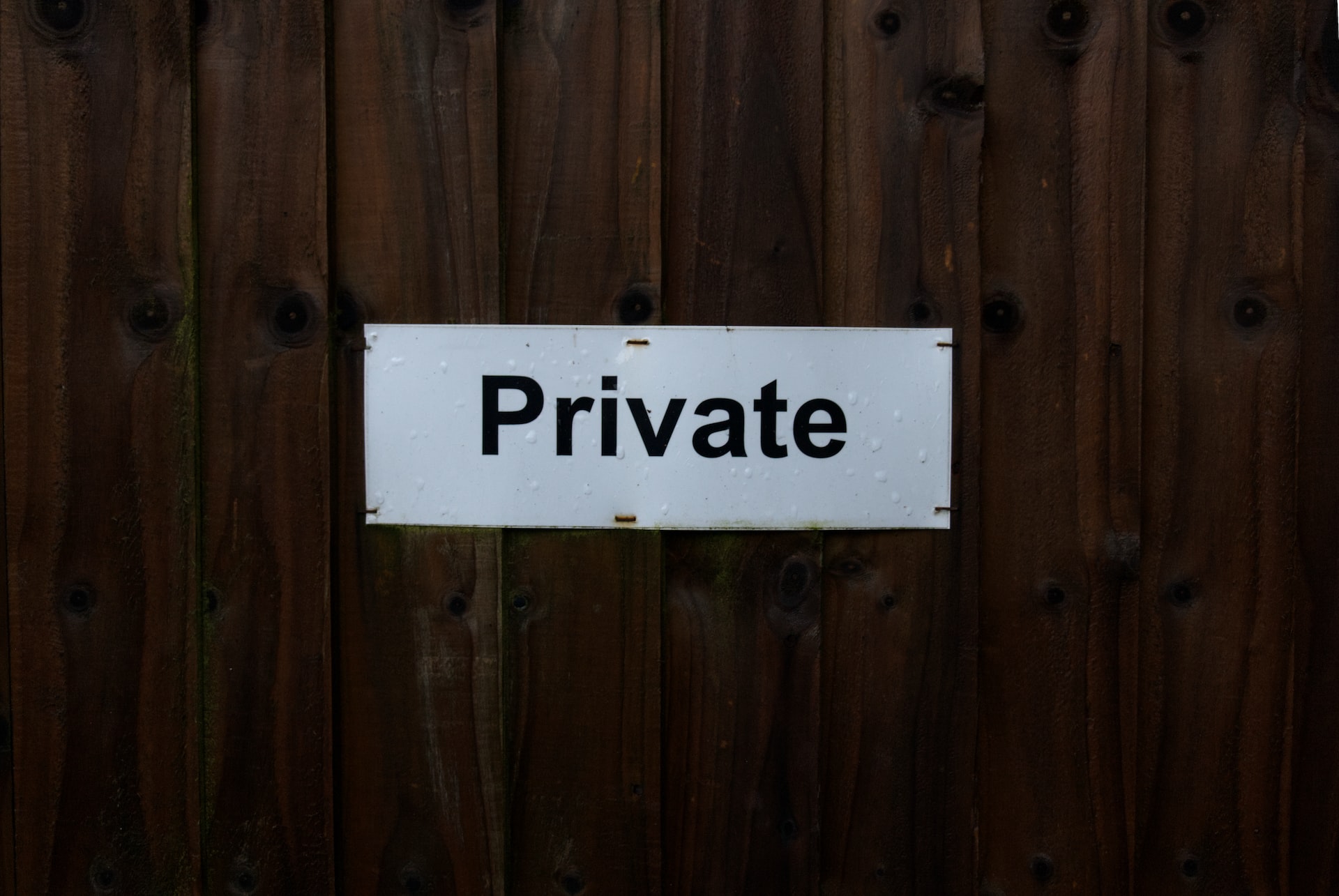 white and black wooden sign saying Private